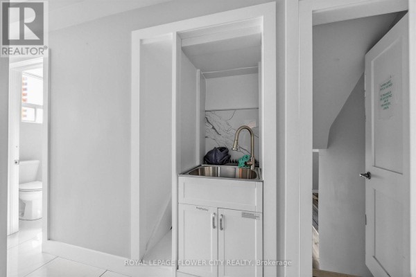 Laundry room with sink, cabinets, marble backsplash, and toilet - 79 Kimberly Drive Hamilton