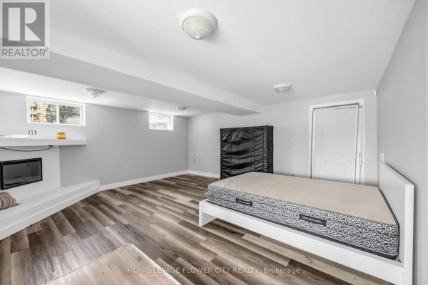 Basement with fireplace, bed, wardrobe and laminate flooring - 79 Kimberly Drive Hamilton