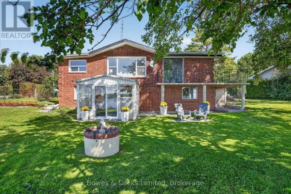 View of the second-story balcony with black metal railings, attached to a red brick house. - 79 Oakdene Crescent, Kawartha Lakes