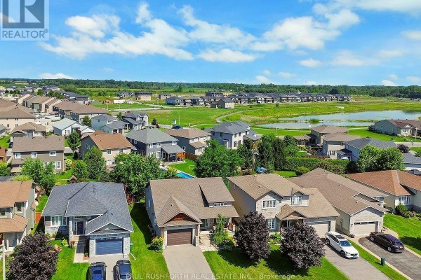 Aerial view showing multiple houses and a pond in a suburban neighborhood under a blue sky. - 79 Settlement Lane, Russell