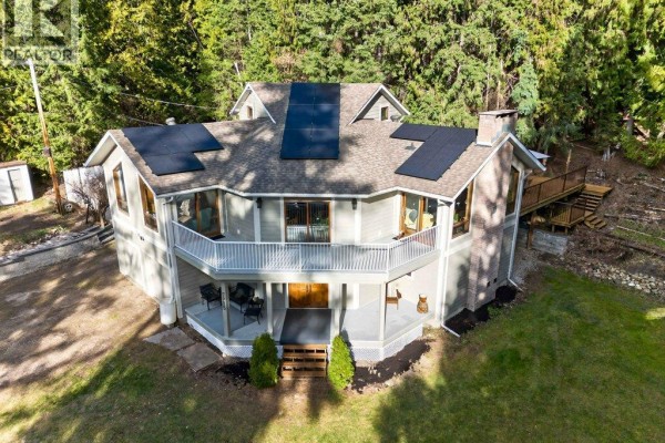 Aerial view of a light grey house with a wrap-around balcony and solar panels on the roof. - 7905 97a Highway, Mara