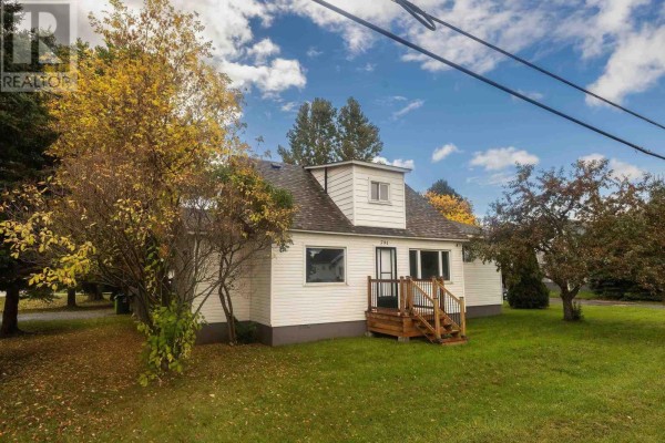Side view of a white sided bungalow with autumn trees and green lawn. - 791 Second Lin W, Sault Ste  Marie