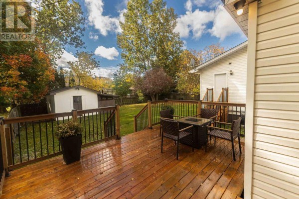 Wooden deck with chairs and a fire pit, overlooking a backyard with a shed. - 791 Second Lin W, Sault Ste  Marie