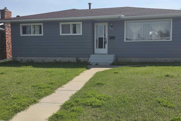 Front view of a gray bungalow with snow-covered landscape and large windows. - 7911 145 Av Nw Nw, Edmonton