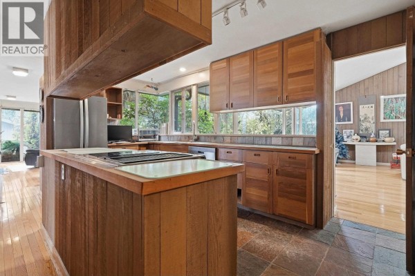 Sunroom with wood floors and paneled walls, featuring large windows and outdoor access. - 792 W 54th Avenue, Vancouver