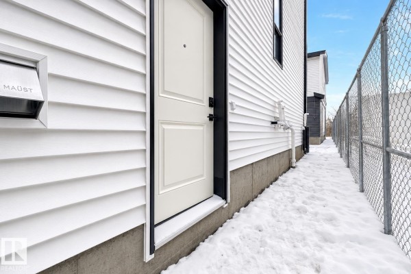 Spacious living area with vaulted ceiling, white walls, and light wood floors. - 7927 112s Av Nw, Edmonton