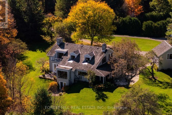 Aerial view of a grey house with dormer windows surrounded by vibrant autumn trees. - 794575 Mono Centre Road, Mono