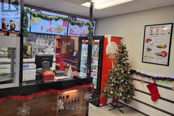 Counter with Christmas decorations, a computer, digital menus, and a soda cooler. - 795 9th Avenue E, Owen Sound