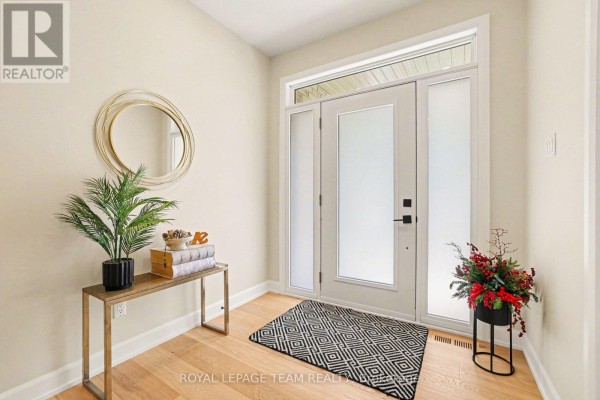 Foyer with light wood floors, frosted glass doors, and a console table. - 7a King Street N, Ottawa