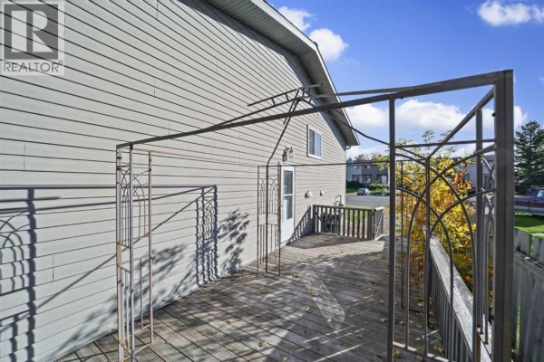 Wooden deck with a metal pergola structure and a back door on the side of the duplex. - 7a Westhill Place, Didsbury
