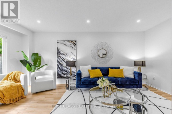 Living room with a blue sofa, two white armchairs, and a large abstract wall art. - 8 - 16 Woodglen Way, Markham