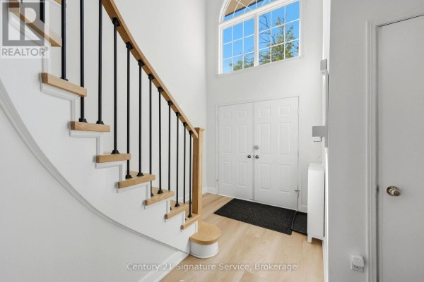 Bright foyer with white walls, light wood floors, and modern staircase with black railings. - 8 - 500 Silverthorne Crescent, Mississauga