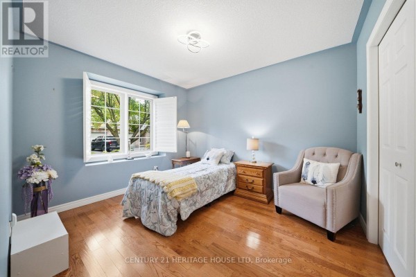 Bedroom with light blue walls, a single bed, an armchair, and a large window. - 8 - 633 Park Road N, Brantford