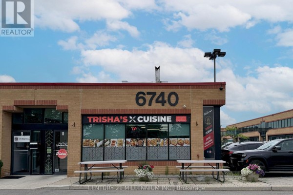 Front facade of 'Trisha's Cuisine' restaurant at 6740 Davand Drive, featuring outdoor picnic tables. - 8 - 6740 Davand Drive, Mississauga