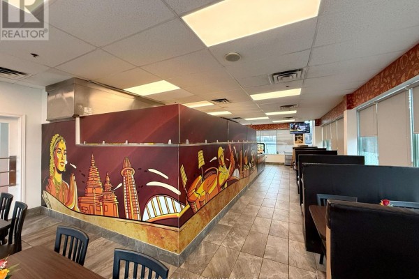 Interior view of a restaurant dining area with maroon and gold murals, booths, and tiled floors. - 8 - 6740 Davand Drive, Mississauga