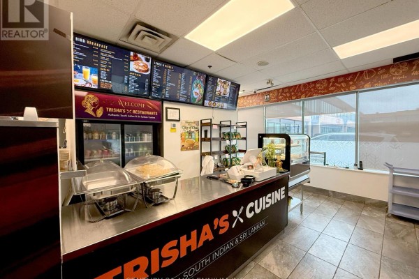 Counter area of a restaurant with menu boards, refrigerated display cases, and stainless steel preparation surfaces. - 8 - 6740 Davand Drive, Mississauga