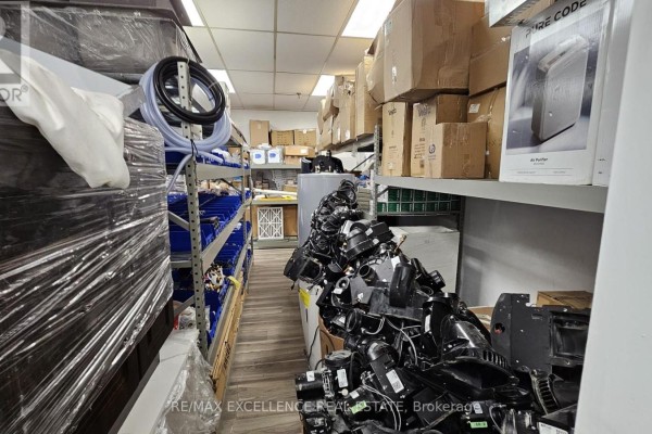 Metal shelving unit displaying packaged tools and hardware supplies, with a BHS sign. - 8 - 7040 Torbram Road, Mississauga