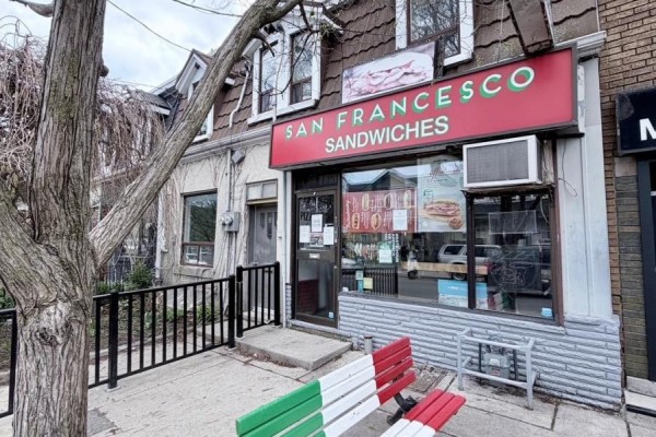 Close-up of the sandwich shop entrance and signage with an Italian-themed bench outside. - 8-10 Clinton Street, Toronto