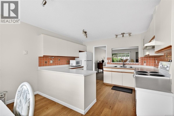 Kitchen view highlighting appliances, counter space, and staircase - 8 130 Corbett Rd, Salt Spring