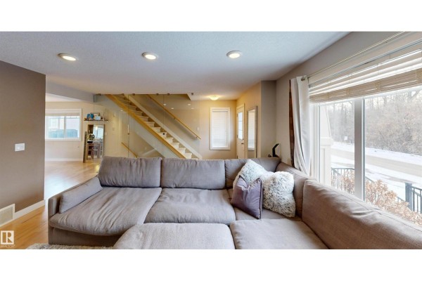 Glass partition showcasing a staircase with wooden steps and a view of the entrance area. - #8 9535 217 St Nw, Edmonton