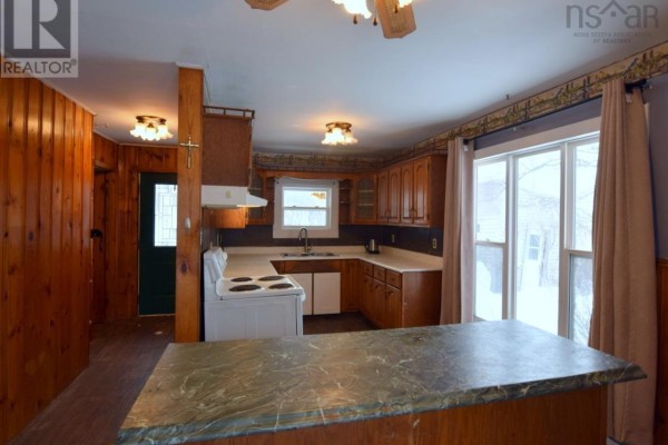 Rear view of duplex surrounded by snow and trees, showing deck area. - 8 Allan J Memorial Avenue, Inverness
