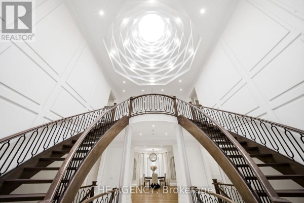 View upwards from the foyer showing a geometric skylight and the double staircase. - 8 Bayview Park Lane, Richmond Hill
