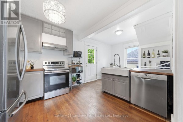 Kitchen with stainless steel appliances, gray cabinets, wooden countertops, and a farmhouse sink. - 8 Bettes Street, Belleville