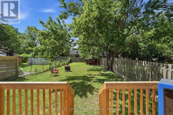 Backyard with a wooden deck, a swimming pool, a fire pit, and mature trees. - 8 Bettes Street, Belleville
