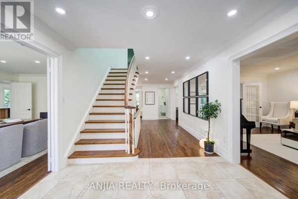 Foyer with a curved staircase, dark hardwood floors, and doorways to other rooms. - 8 Calderbridge Crescent, Markham