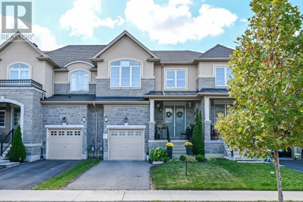 Front exterior view of three interconnected townhouses with stone and beige siding. - 8 Callon Drive, Hamilton