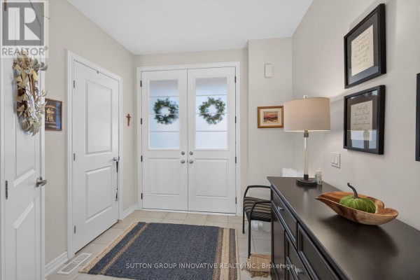 Interior entryway with double doors, console table, lamp, and artwork on walls. - 8 Callon Drive, Hamilton