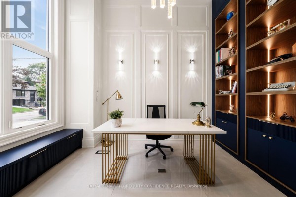 A home office with a white desk, gold legs, black chair, and floor-to-ceiling bookshelves. - 8 Canary Crescent, Toronto