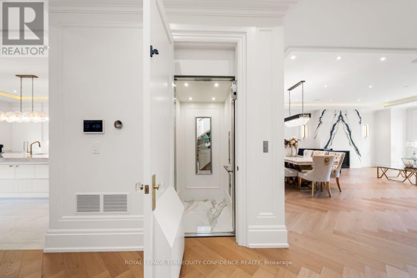 A white elevator with mirrored doors and marble accents in a modern home. - 8 Canary Crescent, Toronto