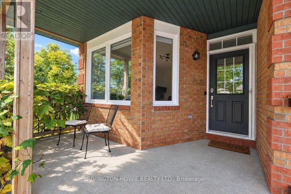 Covered porch with brick exterior, seating area, and front door. - 8 Colindale Avenue, Ottawa