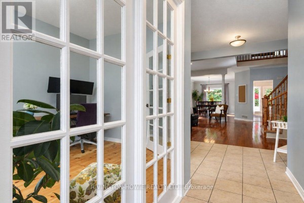 View through glass French doors into a home office and hallway. - 8 Colindale Avenue, Ottawa