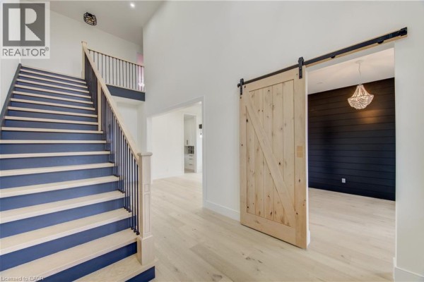 Interior view showing a staircase with dark blue risers and a light wood floor. - 8 Edgeview Crescent, Komoka