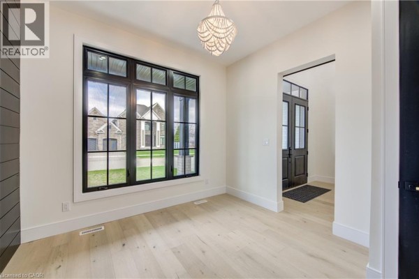 Room with a large window overlooking the street, light wood floors, and an ornate chandelier. - 8 Edgeview Crescent, Komoka