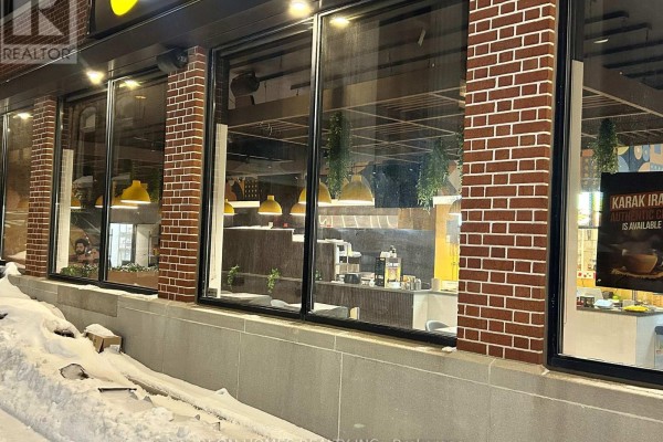 Close-up of a bar area with yellow tile backsplash, glass shelves filled with glassware, and liquor bottles. - 8 Erb Street W, Waterloo