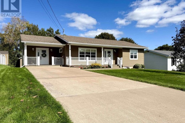 View of the duplex driveway and front entrance with green lawn and blue sky. - 8 Fletcher Drive, Amherst