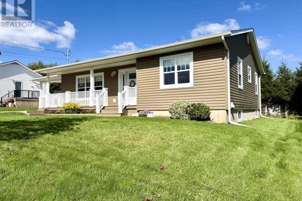 Side view of the duplex showing brown siding, white windows, and green grass. - 8 Fletcher Drive, Amherst