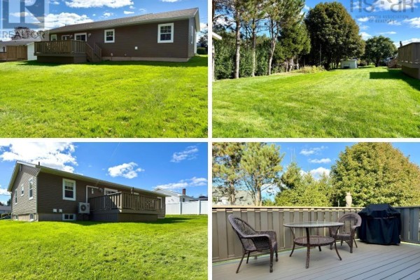 Rear view of the duplex showing a wooden deck, green lawn, and mature trees. - 8 Fletcher Drive, Amherst