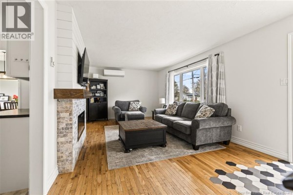 Laundry room with black washer and dryer, shelving, and gray tile flooring. - 8 Gordon Street, Salisbury