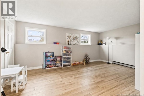 Bedroom with king-size bed, grey bedding, white nightstands, and a ceiling fan. - 8 Gordon Street, Salisbury