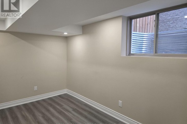 Finished basement room with a small horizontal window and beige walls, with grey laminate flooring. - 8 Hassard-short Lane, Ajax