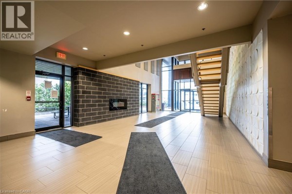 Wide view of the building lobby, showcasing tiled floors and modern staircase. - 8 Hickory Street W Unit# 404, Waterloo