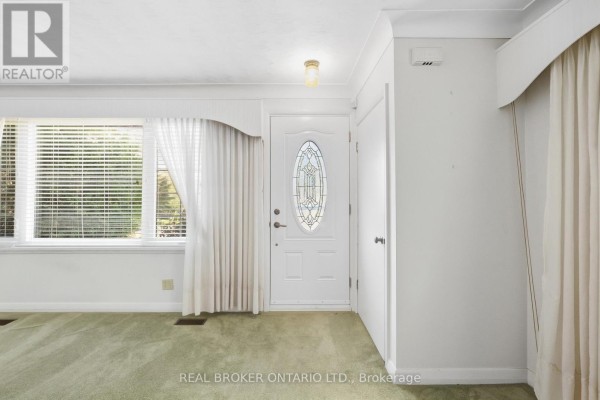 Interior view of the entryway of a home with white walls, green carpet, and a glass-paneled door. - 8 Hill Place, Hamilton