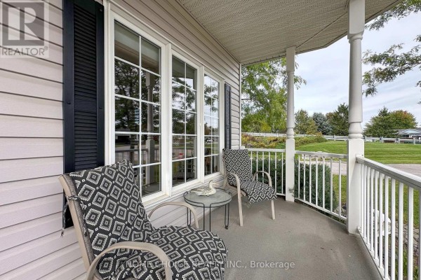 Open concept kitchen and living area with hardwood floors, wood cabinets, and a white stove. - 8 Hinkley Trail, Clarington