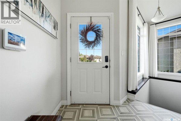 Front entrance foyer with a white door with glass panes and a wreath. - 8 Lott Road E, White City