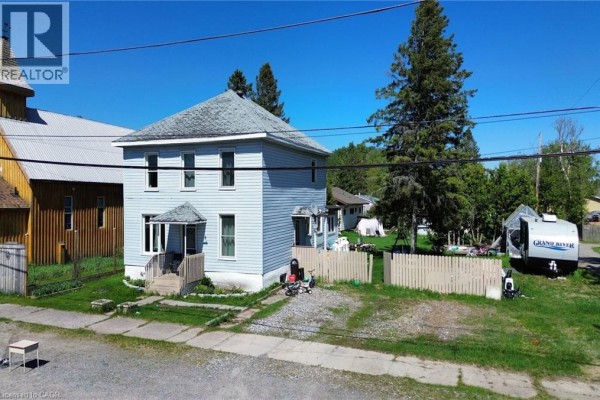 Exterior view of a two-story light blue house with a pitched roof and white trim. - 8 Nelson Street, Webbwood