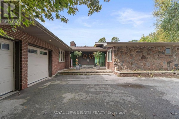 Front exterior of a brick and stone house with a double garage and double front doors. - 8 Ridgevale Drive, Markham